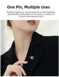 Close-up of geometric gold brooch with crystals worn on a black suit jacket lapel