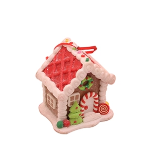 Detail of a Christmas gingerbread house ornament with a red roof and white icing accents