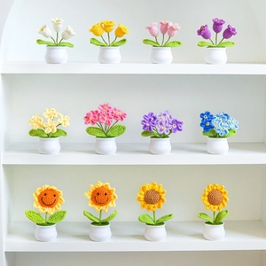 Macro view of assorted handmade crochet potted flowers including tulips and sunflowers