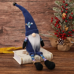 Christmas faceless gnome with blue pointed hat and long striped legs on vintage books