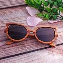 Top view of retro wooden texture sunglasses with polarized lenses on a rustic surface