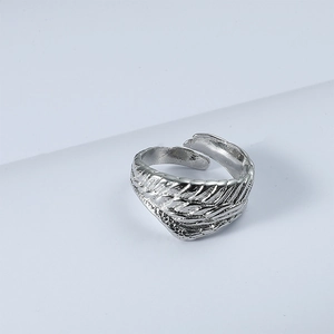 Macro shot of silver adjustable open ring showing detailed feather texture and carving