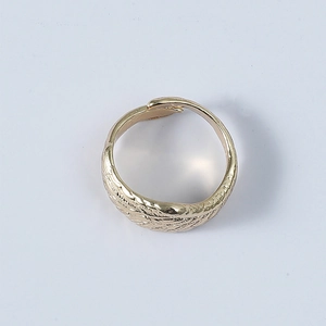 Detail view of golden angel wing ring featuring intricate feather textures and open band