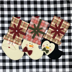 Three Christmas stockings with Santa Snowman and Penguin on checkered fabric