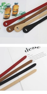 Detailed view of four leather belts in red, brown, beige, and black with pebble texture