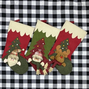 Three Christmas stockings with Santa, Snowman and Reindeer appliques on plaid fabric
