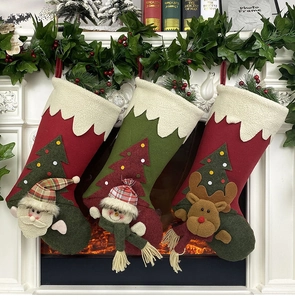 Three plush Christmas stockings with 3D Santa, Reindeer and Snowman on a fireplace mantle
