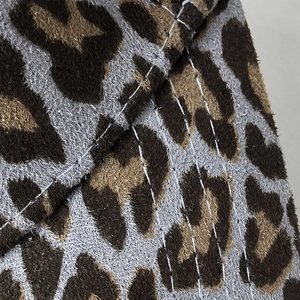 Macro shot of faux suede baseball cap featuring leopard print and white stitching detail