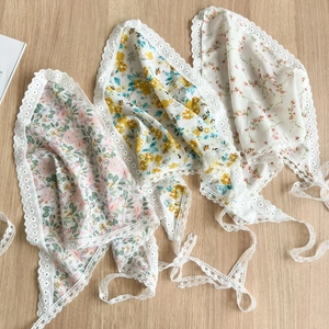 Floral print triangle head scarves with lace trim in white and pink displayed on wood