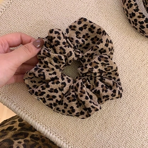 Elastic vintage leopard print scrunchie made of soft fabric held in hand