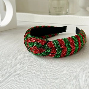 Detail of a Christmas headband featuring red and green metallic striped fabric with knot design