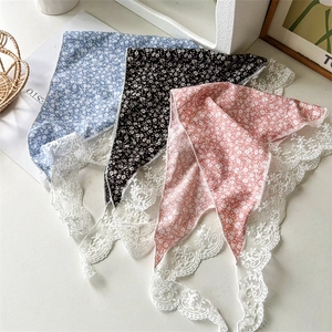 Detailed view of floral silk scarves with white lace edges in blue, black, and pink colors