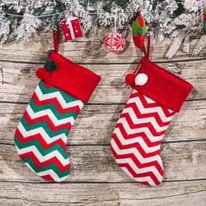 Large knitted striped Christmas socks with red white green patterns and pompom charms