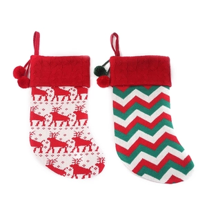 Knitted Christmas stockings set featuring reindeer patterns and pom-poms on white background