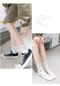Detail of white cotton crew socks with carrot and banana patterns and ruffled edges