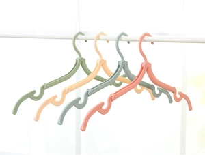 Close-up of portable folding hangers in pastel colors hanging on a rod for travel
