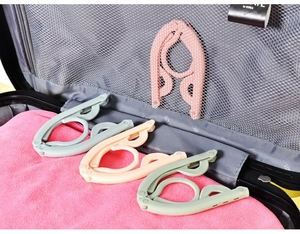 Foldable travel clothes hangers in pastel colors organized inside a travel suitcase