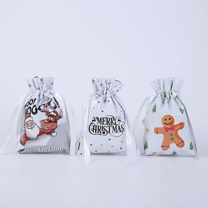 Three Christmas drawstring gift bags featuring Santa, reindeer, and gingerbread man motifs