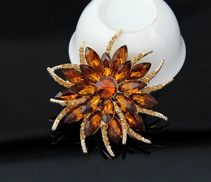 Detailed macro view of an amber crystal sunflower brooch with golden metal petal accents