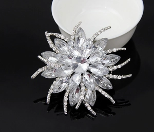 Macro shot of silver floral crystal brooch with sparkling rhinestones and petal details