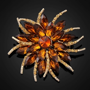 Detailed close-up of a floral crystal brooch with amber marquise gems and gold setting