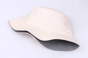 Detail of a beige and gray cotton bucket hat featuring precise stitching and high-quality fabric