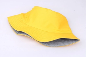 Detail of yellow and gray reversible sun hat showing dual-color brim and fabric texture