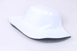 Detail view of the reversible white and grey sun hat showing the fabric texture and dual sides