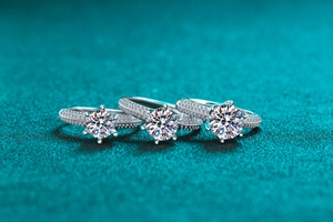 Macro detail of three silver rings with round-cut moissanite and pave setting