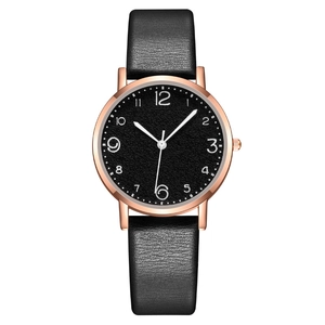 Minimalist women's watch with black leather strap and rose gold case on white background