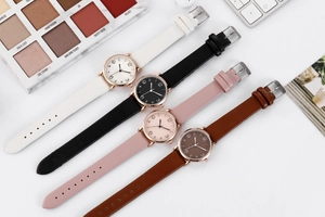 Flat lay of women's quartz watches with leather straps in white, black, pink, and brown
