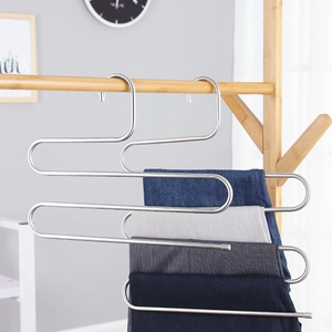 Detail showing an S-shaped stainless steel multi-layer hanger holding three pairs of pants