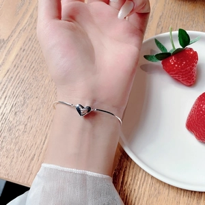 Close-up of minimalist S925 sterling silver heart bracelet worn on a woman's wrist