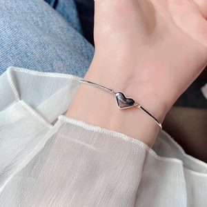 Detailed view of the elegant silver heart bracelet on a female wrist for a chic look