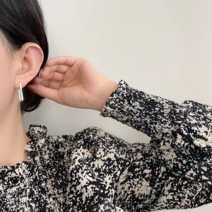 Side view detail of a model wearing minimalist silver rectangular drop earrings