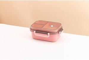 Close-up of double-layer lunch box with pink base and brown transparent dividers