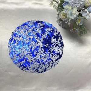 Detailed view of the blue marble texture and metallic silver finish on a round placemat