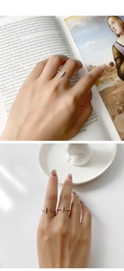 Detail of gold and silver T-shaped open rings with pavé zircon on vintage book pages