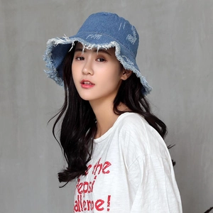 Classic distressed blue denim bucket hat with raw edges worn by a model in profile view