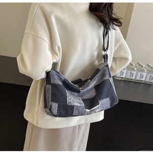 Detail of blue denim patchwork crossbody bag with checkerboard pattern on casual outfit