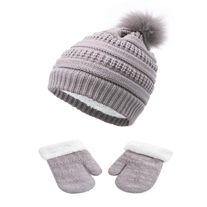 Dettaglio di cappello e guanti in maglia grigio chiaro con fodera in pile bianco