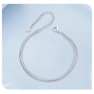 Detailed macro of S925 sterling silver triple-layer bracelet with heart charm and lobster clasp