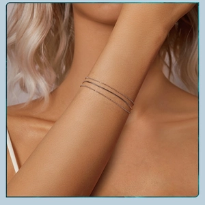 Detailed view of three minimalist silver layered bracelets on a wrist