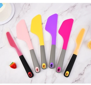 Set of six colorful silicone spatulas on marble background with cake and fruit