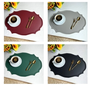 Detailed view of oval faux leather placemats in four colors with stitched scalloped edges
