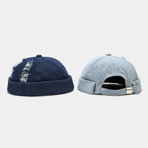 Detailed close-up of blue denim brimless docker hats with distressed ripped design details
