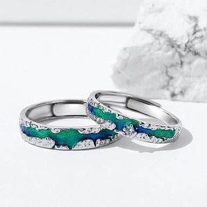 Macro shot of silver couple rings with blue gradient inlay and textured rock finish