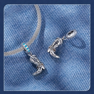 Macro view of S925 sterling silver cowboy boot charm with blue turquoise gemstone