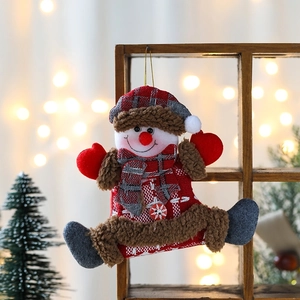 Hanging Christmas snowman ornament with red checkered fabric on a wooden festive background