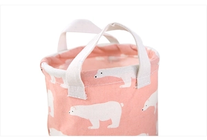 Close-up of pink canvas storage bin featuring polar bear print and durable side handles